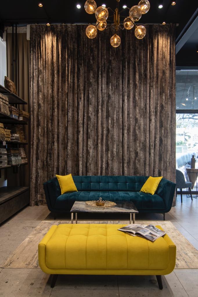 Showroom lounge with velvet sofa and textured drapery